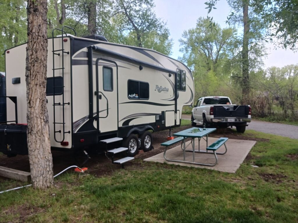 a travel trailer and pickup parked at tall texan rv park