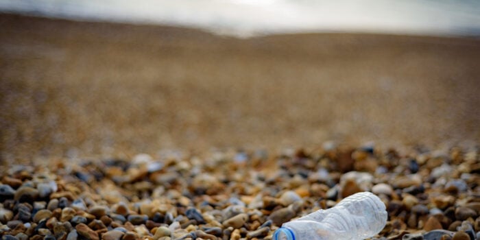 plastic bottle on beach - feature image for how to reduce plastic use in an RV