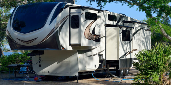 Fifth wheel trailer with slideouts extended in campsite