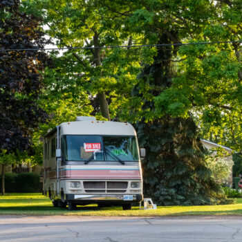 RV in yard with for sale sign in window - feature image for RV value