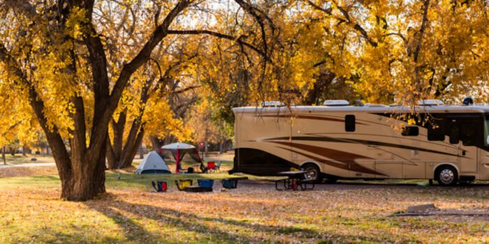 large RV and small tent at campsite camping in the fall