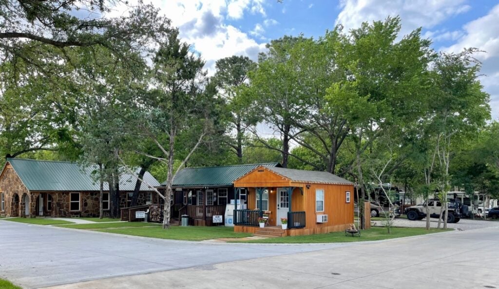 A tiny house, cabin, and clubhouse at the entry of Lake Dallas RV Park