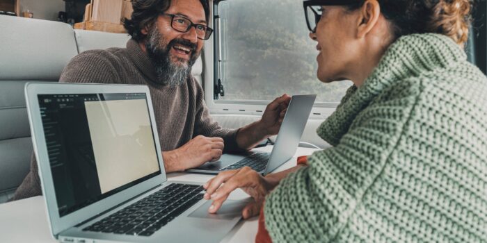 Man and woman use laptops in an RV