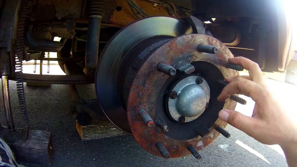 Person's hand inspecting brakes.