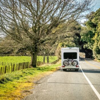 RV trailer on road, feature image for full-time RV living monthly costs