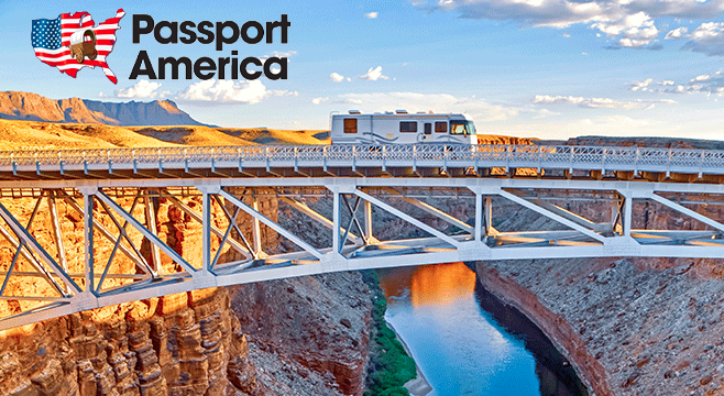 RV crosses gorge on bridge with Passport America logo.