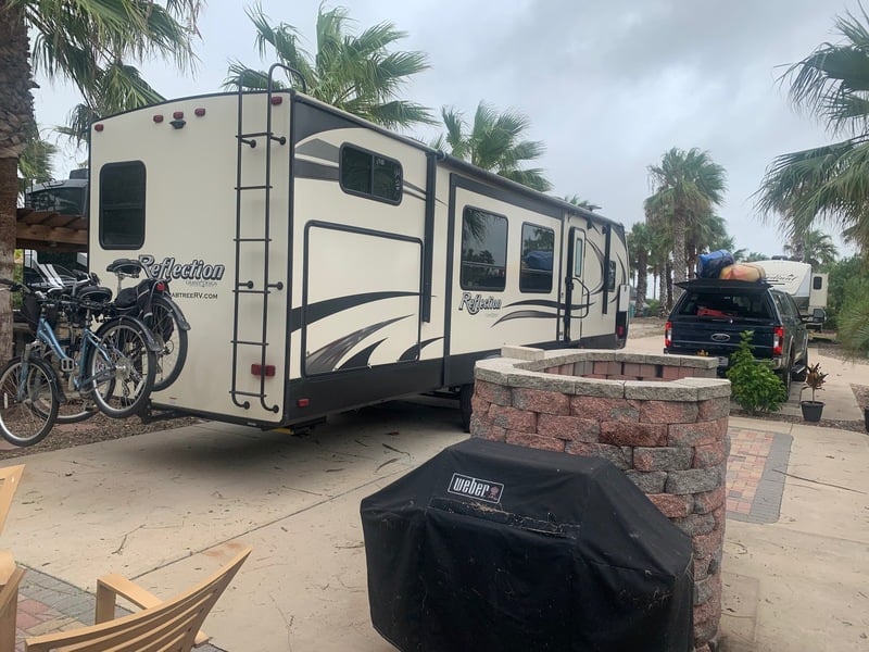RV in campsite surrounded by palm trees