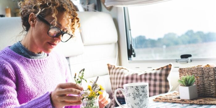 woman caring for house plants inside motorhome (Image: Shutterstock)