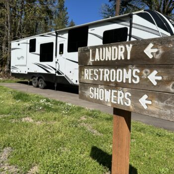 a sign on the side of a road that says laundry, restrooms, showers, and restrooms