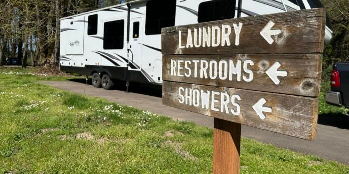 a sign on the side of a road that says laundry, restrooms, showers, and restrooms
