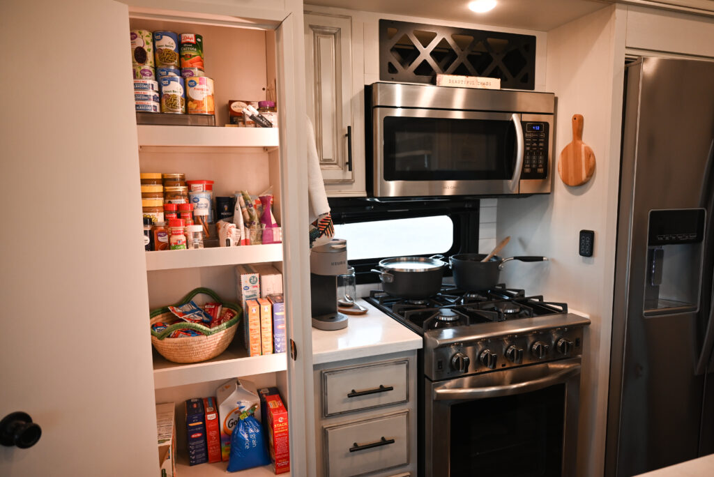 a stainless steel stove top oven sitting inside of a kitchen next to a refrigerator and a refrigerator freezer