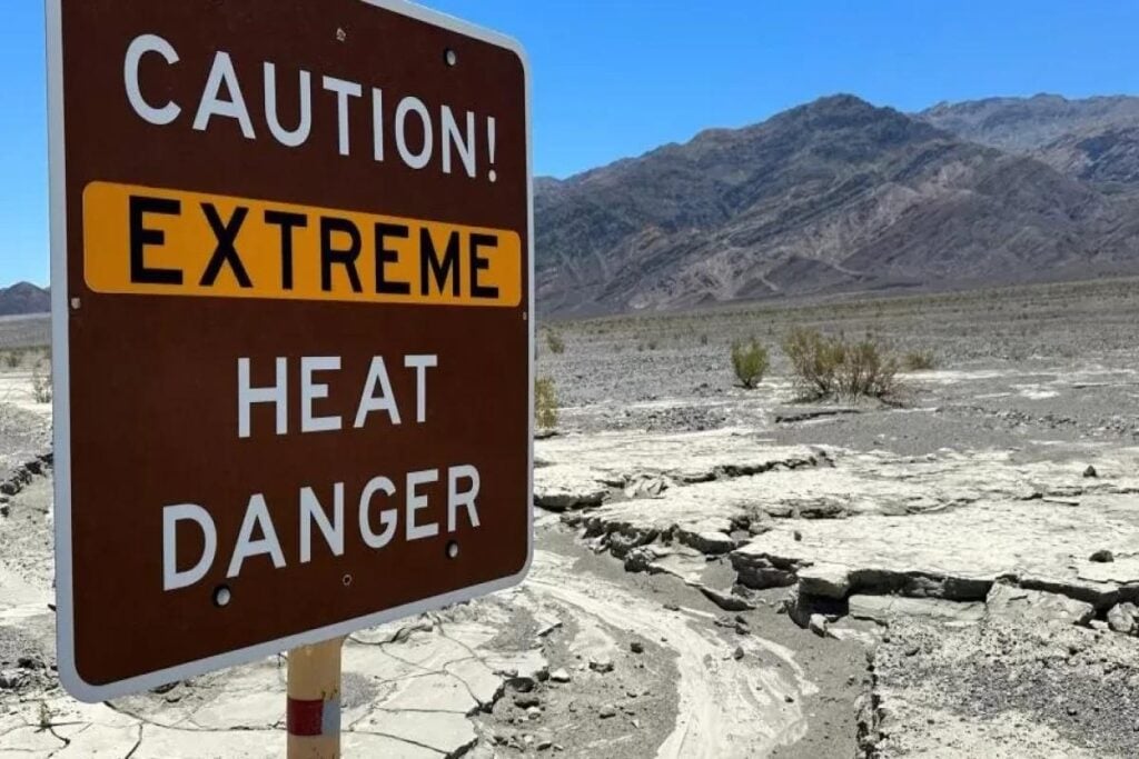 A warning sign next to a desert warning of extreme heat