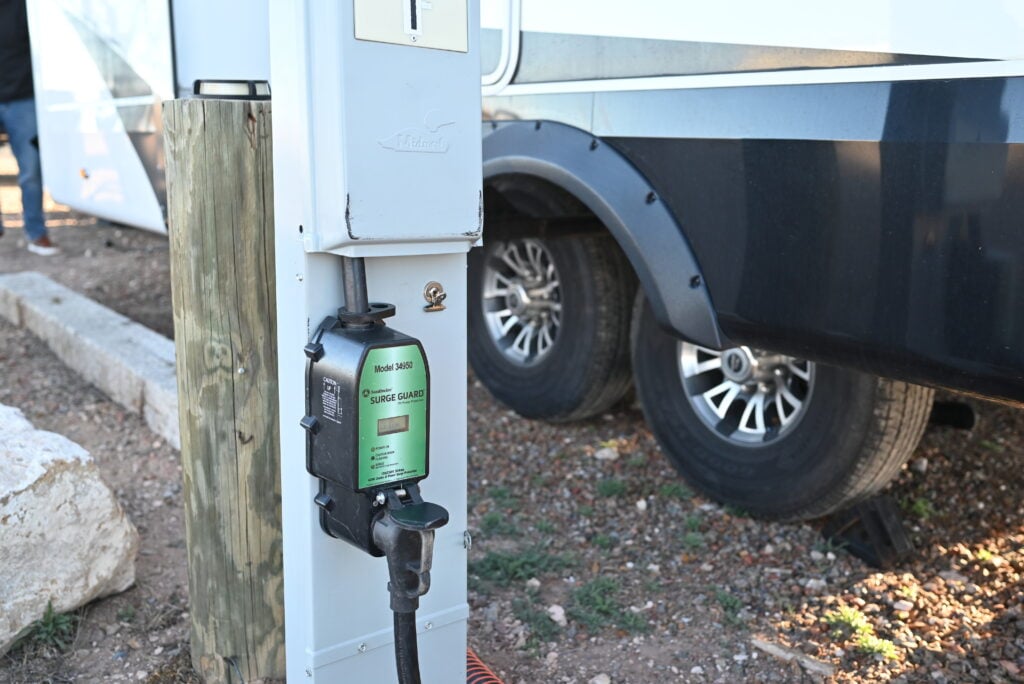 a close up of a gas pump attached to the side of a white truck parked on the side of a road, image for safety devices