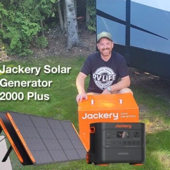 Man sits next to Jackery Solar Generator and Solar Panels