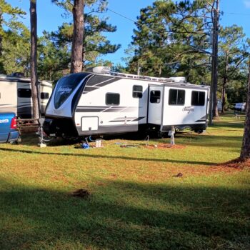 A travel trailer in a campsite at New Green Valley RV Park.