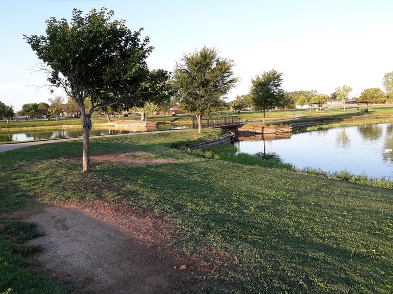 view of green grass, trees and pond near free RV hookups