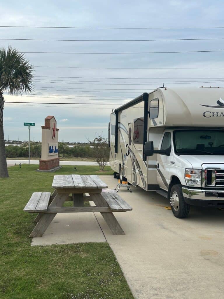 A Class C motorhome and picnic table in a campsite at Stella Mare RV Resort.