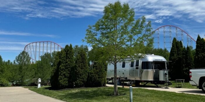 RVing in Kansas City: An Airstream trailer at Worlds of Fun Village RV park, with a roller coaster track in the background.