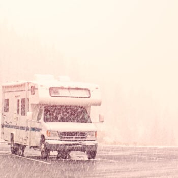 Class C motorhome in a parking lot during a snow storm