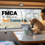 woman with small dog uses laptop in an RV.