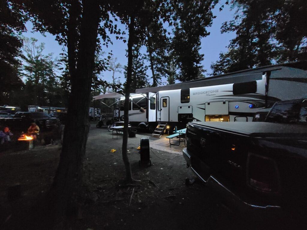 A nighttime scene where a trailer is illuminated in a site at the top-rated RV campground, Sea Pirate Campground.
