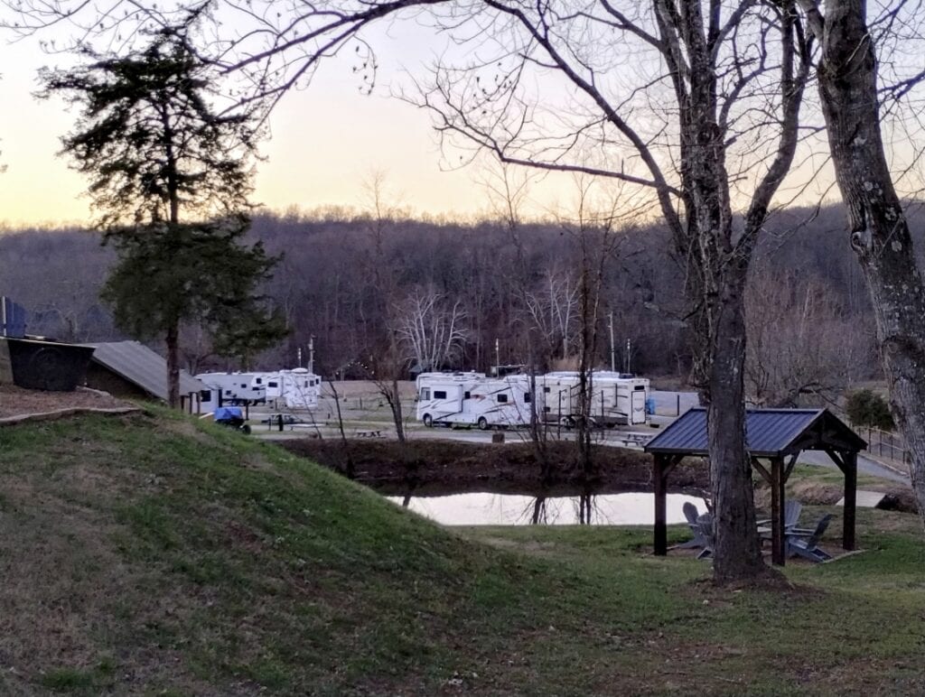Three campsites at Piney River RV Resort, with Class C motorhomes and fifth-wheels in each site.