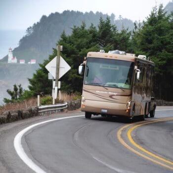 A Class A motorhome equipped with an RV steering stabilizer driving down a highway with the ocean in the background. Photo: Bruce W. Smith.