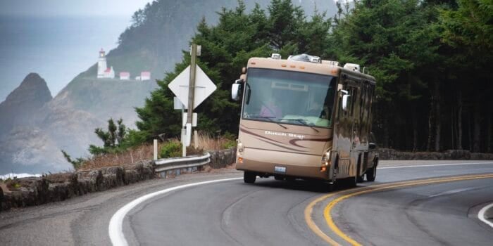 A Class A motorhome equipped with an RV steering stabilizer driving down a highway with the ocean in the background. Photo: Bruce W. Smith.