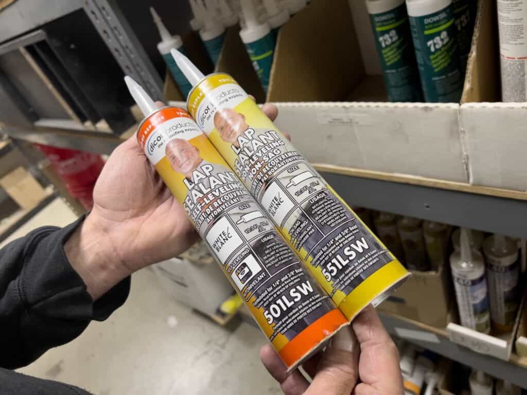 A man holding two tubes of self-leveling lap sealant from Dicor. Photo: Bruce W. Smith