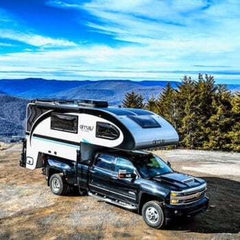 Cirrus truck camper on a bluff overlooking mountains. Photo: nuCamp RV.