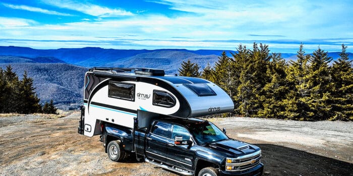 Cirrus truck camper on a bluff overlooking mountains. Photo: nuCamp RV.