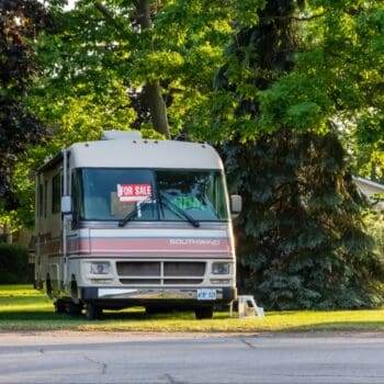 RV in yard with for sale sign in window