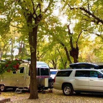 A scenic RV site at Rancho Sedona RV Park, with an SUV and an Airstream trailer.