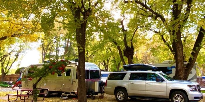 A scenic RV site at Rancho Sedona RV Park, with an SUV and an Airstream trailer.