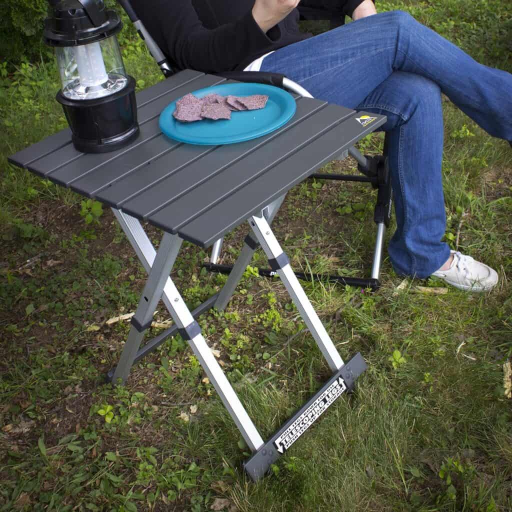 A person sitting next to a CGI Outdoor table. Photo courtesy Amazon.com.