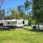 A fifth-wheel RV camping in Louisiana at a campsite at Fireside RV Resort.