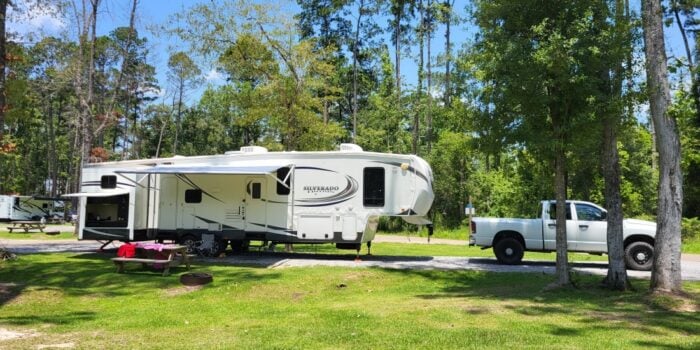 A fifth-wheel RV camping in Louisiana at a campsite at Fireside RV Resort.